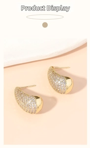 Detailed view of luxury gold teardrop earrings with pavé white zircon crystals