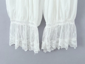 Nahaufnahme der weißen Baumwollshorts mit feiner Spitzenstickerei am Beinsaum
