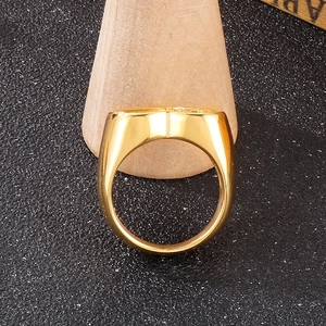 Macro di anello largo dorato lucido su supporto in legno con sfondo strutturato vintage