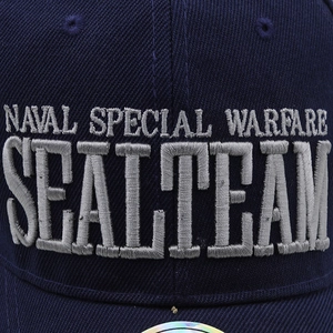 Dettaglio del ricamo argento sul berretto tattico blu scuro con logo Navy Seal e scritte