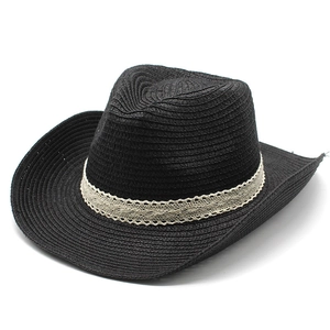 Detail of woven black cowboy straw hat featuring elegant cream lace ribbon trim