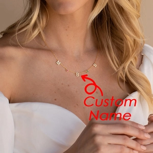 Detalle de collar personalizado de oro con colgantes de letras y piedras de nacimiento