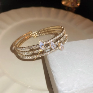 Macro shot of three-layer gold bangle with marquise cubic zirconia and sparkling pavé stones