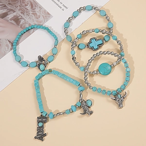 Detail of bohemian turquoise beaded bracelets with western charms like cactus and cow skull