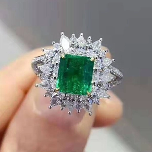 Vue macro d'une bague fleur avec zircon vert taille émeraude et pavé de diamants