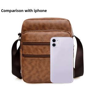 Brown PU leather shoulder bag with multiple zippers shown next to an iPhone for scale