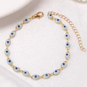 Detailed close-up of golden evil eye anklet with lobster clasp on a white background