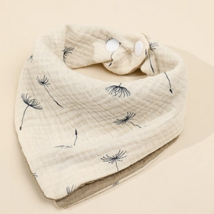 Detail of four-layer cotton baby bib featuring dandelion print and snap fasteners