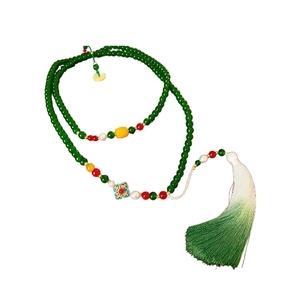 Traditional beaded necklace with green beads, pearls, and a floral tassel pendant