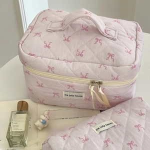 Detailed view of quilted cotton makeup bags with pink ribbon pattern and zipper pulls