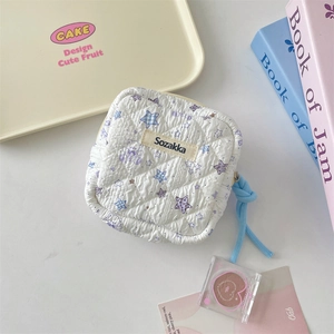 Detailed view of quilted cartoon bear sanitary napkin storage bag with zipper and logo