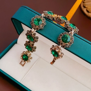 Macro shot of green gemstone bracelet with gold setting on a velvet jewelry box