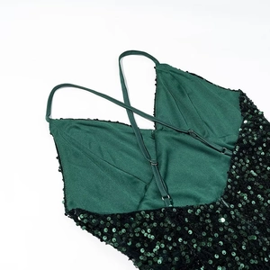 Detail of dark green sequin dress showing thin criss-cross back straps and fabric texture