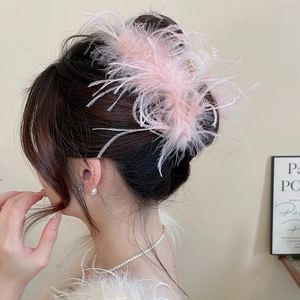 Detail view of a pink ostrich feather hair claw clip on elegant updo hairstyle