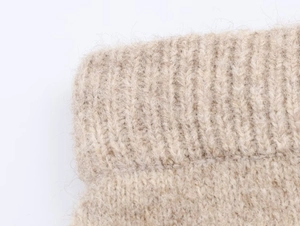 Macro di maglia a coste beige che mostra il morbido misto lana e i polsini elasticizzati