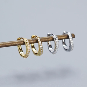 Close-up of gold and silver S925 sterling silver hoop earrings with zircon stones
