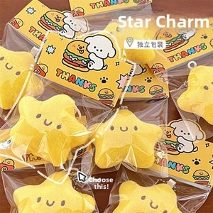 Close-up of plush yellow star charms with smiley faces in individual retail packaging