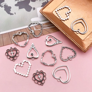 Detailed view of silver hollow heart charms in various styles for DIY jewelry making