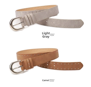 Close-up of suede leather belts in light grey and camel with silver studs and pin buckles