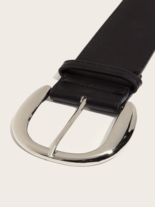 Detailed view of black leather belt with oversized silver oval buckle and stitching