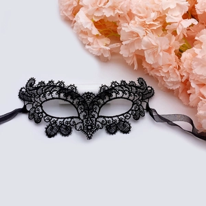 Detail of black hollow lace masquerade mask with fine embroidery and silk ribbon ties