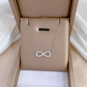 Silver infinity bow necklace with micro-diamonds in a beige luxury jewelry gift box