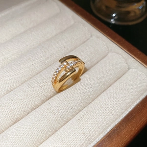 Macro detail of 18k gold plated H-shaped ring with pavé cubic zirconia accents