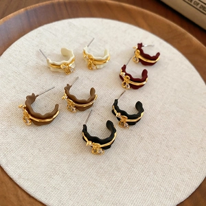 Detail of 18k gold plated C-shaped earrings with bowknot and zircon in four colors