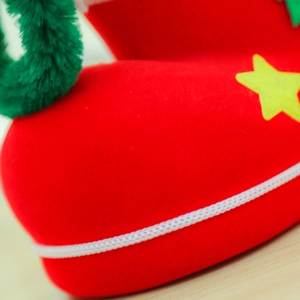 Macro detail of red flocked Christmas boot ornament with green fur trim and yellow star