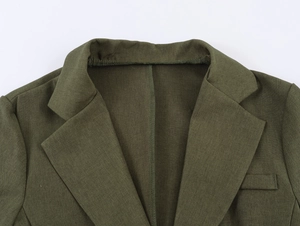 Détail du revers d'un blazer vert armée montrant la texture du lin et la poche