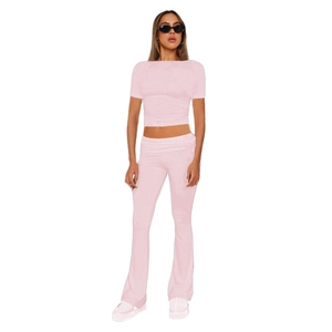 Detail showing pink two-piece set with a slim-fit short sleeve top and flared trousers