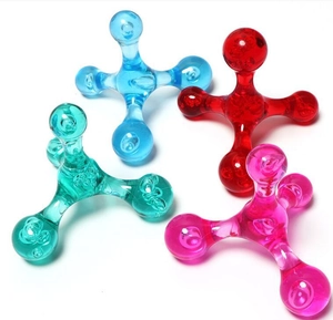 Flat lay of four colorful star-shaped plastic massage tools in blue red green and pink