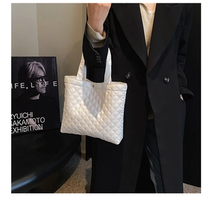 Dettaglio della borsa a secchiello trapuntata bianca con eleganti cuciture a rombi