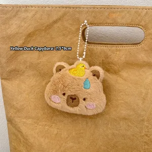 Detail eines Capybara Plüschanhängers mit Ente, Größe 7,5x9cm an einer braunen Tasche