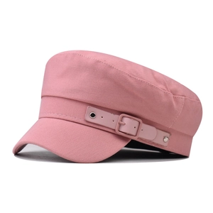 Detailed close-up of pink cotton newsboy hat with leather strap and metal buckle accent