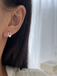 Close-up of elegant 925 sterling silver pearl earring worn on model's ear
