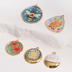 Golden titanium steel oval pendants with bee, lion and floral painted designs