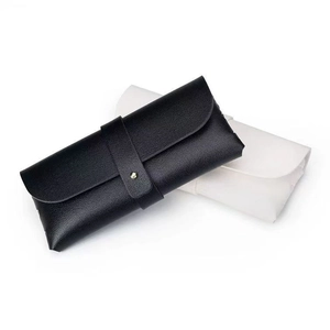 Minimalist faux leather glasses case in black and beige with secure gold button closure