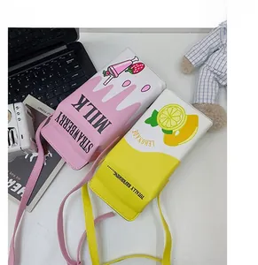 Detail of pink strawberry and yellow lemon milk box crossbody bags with adjustable straps