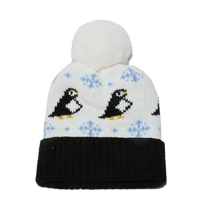 Detail of penguin jacquard knit hat with white faux fur pompom and ribbed cuff