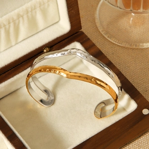 Two-tone gold and silver hammered bangles displayed in a premium wooden jewelry box