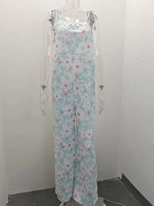 Detail of floral spaghetti strap jumpsuit featuring wide-leg cut and soft petal pattern
