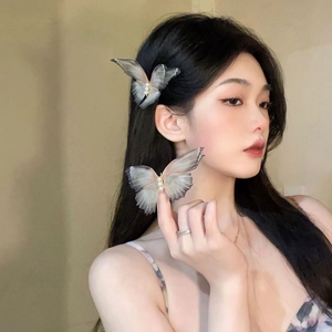 Close-up of mesh butterfly hair clip with translucent grey gradient and pearl details