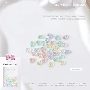 Macro shot of 6x8mm aurora resin heart nail charms with starry glitter and retail pack
