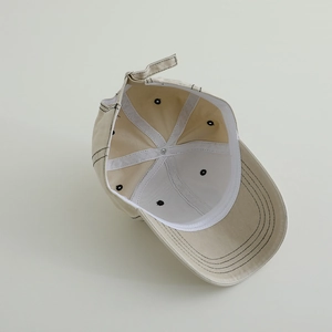 Inside view of beige kids baseball cap with contrast stitching and adjustable strap