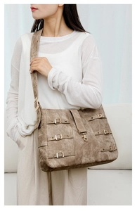 Detail of vintage brown oversized tote bag with metal buckles and wide shoulder strap