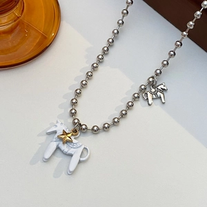 Dettaglio catena a sfere con ciondolo a forma di cavallo bianco e charm in argento vintage