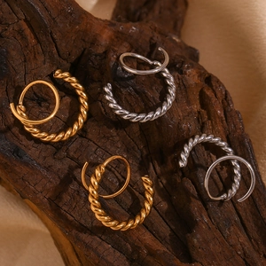 Detailed macro shot of twisted double hoop earrings in gold and silver steel