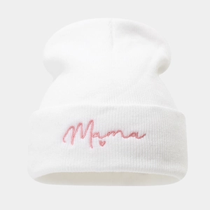 Detailopname van de witte gebreide muts met roze Mama-borduurwerk en klein hartdetail