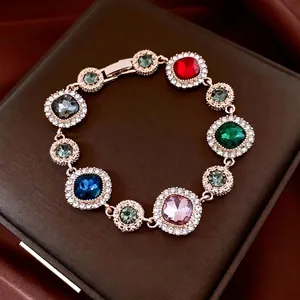 Luxury vintage gold bracelet with multi-color rhinestones on a brown leather box